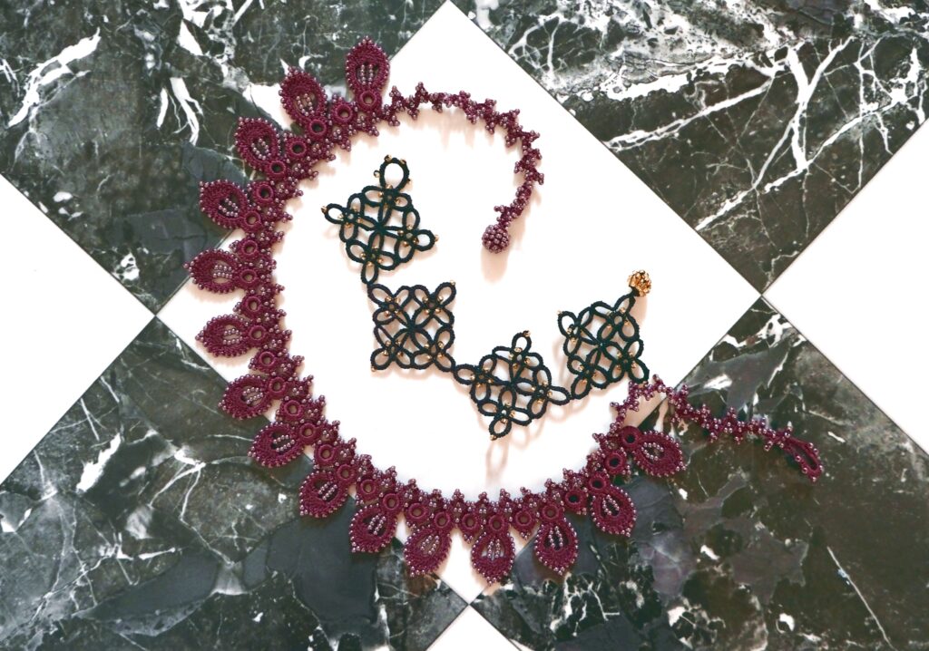 Purple and black Oya lace jewellery on a tiled background.